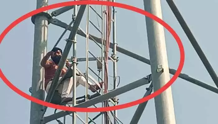 A villager from Duddnapally climbed a tower demanding justice over a disputed land sale; police calmed him down.